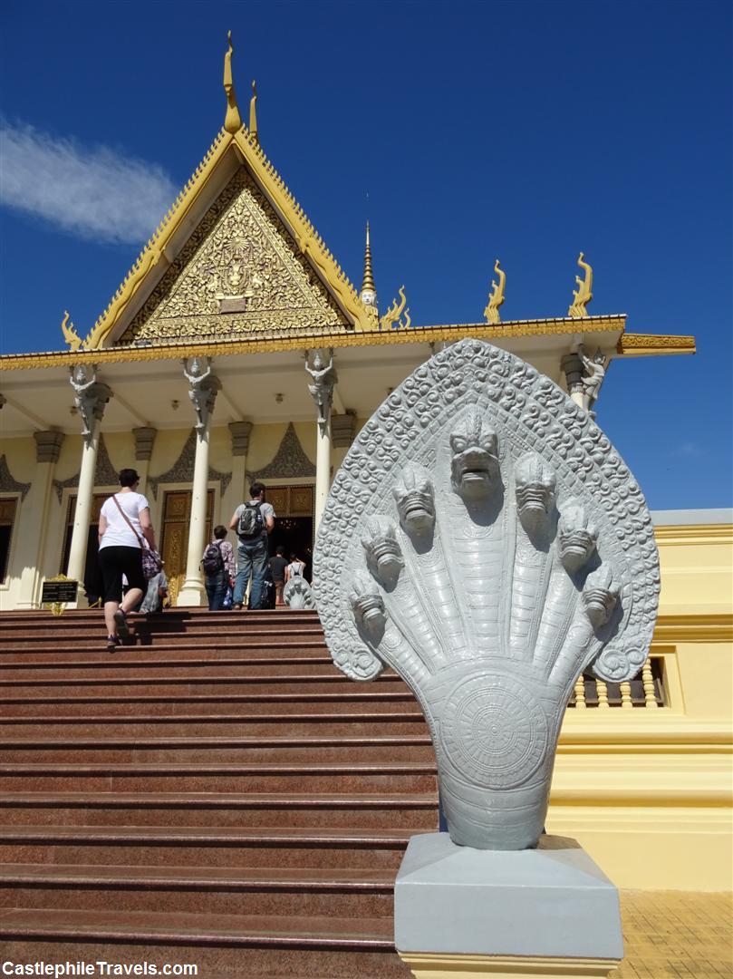 A naga stands at the foot of the steps to the throne room.